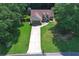 Aerial shot shows the home on a landscaped lot with mature trees, long driveway, and private backyard at 106 Kimbell Farm Dr, Locust Grove, GA 30248