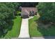 Aerial shot shows the home on a landscaped lot with mature trees, long driveway, and private backyard at 106 Kimbell Farm Dr, Locust Grove, GA 30248