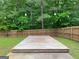 Backyard with a large deck, string lights, and a fence, creating a cozy outdoor space at 106 Kimbell Farm Dr, Locust Grove, GA 30248