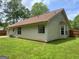 Exterior view of the home's side and backyard, showcasing the lawn and perimeter fencing at 106 Kimbell Farm Dr, Locust Grove, GA 30248