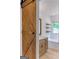 Bright bathroom features a sliding barn door and soaking tub with wood-look floors and a white color scheme at 106 Kimbell Farm Dr, Locust Grove, GA 30248