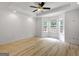 Bedroom features ceiling fan, light-colored hardwood floors, large windows, and tray ceiling design at 106 Kimbell Farm Dr, Locust Grove, GA 30248