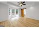 Corner bedroom boasts bright windows, ceiling fan, hardwood floors, and an adjacent bathroom with barn door access at 106 Kimbell Farm Dr, Locust Grove, GA 30248