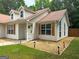 View shows the side of the home and entryway, with manicured landscaping, dormer windows, and sidewalk at 106 Kimbell Farm Dr, Locust Grove, GA 30248