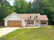 Charming single-story home with dormer windows, a well-manicured lawn, and a spacious two-car garage at 106 Kimbell Farm Dr, Locust Grove, GA 30248