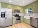 Modern kitchen with stainless steel appliances, green cabinetry, and ample counter space at 106 Kimbell Farm Dr, Locust Grove, GA 30248
