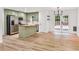 Kitchen boasts stainless appliances, an island, light green cabinets, and flows seamlessly to the outdoor deck at 106 Kimbell Farm Dr, Locust Grove, GA 30248
