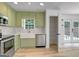 Charming kitchen features stainless steel appliances, farmhouse sink, light green cabinets and butcher block countertops at 106 Kimbell Farm Dr, Locust Grove, GA 30248