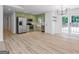 Open living space with light-colored hardwood floors seamlessly integrates kitchen with stainless appliances and outdoor access at 106 Kimbell Farm Dr, Locust Grove, GA 30248
