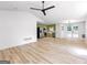 Open-concept living space with hardwood floors, ceiling fan, and access to a modern kitchen at 106 Kimbell Farm Dr, Locust Grove, GA 30248