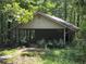 Exterior of an outbuilding with covered parking surrounded by trees and green brush at 106 Kimbell Farm Dr, Locust Grove, GA 30248