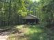Exterior of an outbuilding nestled among the trees with a covered parking area at 106 Kimbell Farm Dr, Locust Grove, GA 30248