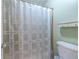 The shower has a neutral-patterned shower curtain at 1225 Church St # M, Decatur, GA 30030