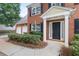 Close up of a red brick home showcasing a two-car garage and charming front entrance at 2683 Berry Ridge Ct, Buford, GA 30519