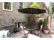 A secluded patio with brick paving features seating under a large umbrella, surrounded by lush greenery at 2283 Falmouth Se Ct # 22, Smyrna, GA 30080