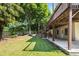 Backyard featuring lush green grass, mature trees, and a shaded patio area at 3053 Ramsey Pl, Marietta, GA 30062