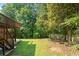Spacious backyard with lush trees, grass, and a wood fence with access from the deck stairs at 3053 Ramsey Pl, Marietta, GA 30062