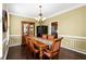 Elegant dining room with dark hardwood floors, a decorative chandelier, and access to the kitchen at 3053 Ramsey Pl, Marietta, GA 30062
