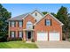 Charming brick two-story home with black shutters, a well-manicured lawn, and a two car garage at 3053 Ramsey Pl, Marietta, GA 30062