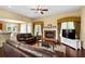 Comfortable living room with a brick fireplace, hardwood floors, and large windows that provide natural light at 3053 Ramsey Pl, Marietta, GA 30062