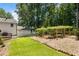 Spacious backyard featuring a large, grassy area, lush foliage, and a wooden deck at 321 Crabtree Court, Marietta, GA 30068