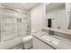 Updated bathroom features marble tile in shower/tub, gray wood-look floors, and marble countertop vanity with white cabinets at 321 Crabtree Court, Marietta, GA 30068