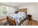 Charming bedroom with wood floors, a comfortable bed, and natural light from a window at 321 Crabtree Court, Marietta, GA 30068