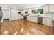 Well-lit kitchen with stainless steel appliances, white cabinets, and hardwood flooring at 321 Crabtree Court, Marietta, GA 30068