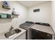 A well-organized laundry room with modern washer and dryer, sink, and shelving for supplies at 321 Crabtree Court, Marietta, GA 30068