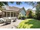 Landscaped backyard showing brick patio with seating, a screened-in porch, manicured lawn and mature trees at 35 Westfair Ct, Atlanta, GA 30328