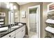Bathroom featuring a granite countertop, double sink vanity, decorative lighting, and adjacent shower at 35 Westfair Ct, Atlanta, GA 30328