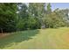 Beautiful backyard with a lush lawn, mature trees, and a grill, ideal for outdoor entertaining at 4445 Hager Ct, Cumming, GA 30040