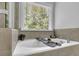 Soaking tub under a window with caddy including live plants and other spa-like decorative items at 4445 Hager Ct, Cumming, GA 30040