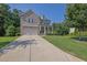 Charming brick home featuring an inviting front porch and well-maintained lawn, surrounded by mature trees at 4445 Hager Ct, Cumming, GA 30040
