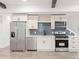 Modern kitchenette with stainless steel appliances, white cabinets, wine rack, and stylish backsplash at 474 Haley Se St, Marietta, GA 30060