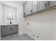 Convenient laundry room with modern gray cabinets, white quartz countertops, sink, and gray floors at 474 Haley Se St, Marietta, GA 30060