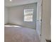 Well-lit bedroom with plush carpet, a window, and a closet with a white paneled door at 15 Barton Ln, Covington, GA 30016