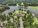 Stunning aerial view of the neighborhood clubhouse, parking, and sprawling green golf course with surrounding trees and lake at 3011 Stillwater Dr, Villa Rica, GA 30180