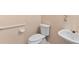 Bright bathroom featuring a white toilet, sink and accessibility hand rail for enhanced comfort at 3011 Stillwater Dr, Villa Rica, GA 30180