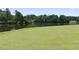 Scenic view of a well-manicured golf course with a flag, lush green grass, and a tranquil lake at 3011 Stillwater Dr, Villa Rica, GA 30180