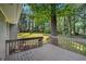View of the backyard featuring a deck, lush greenery, and a big tree at 1260 White Oak Se St, Conyers, GA 30013