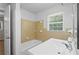 Tiled bathroom with a window above the sink and a shower-tub combo at 1260 White Oak Se St, Conyers, GA 30013