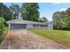 Exterior showcasing the house, driveway, a covered garage, and grass at 1260 White Oak Se St, Conyers, GA 30013