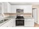 Bright kitchen features granite countertops, stainless steel appliances, and sleek white cabinetry at 2083 Meador Se Ave, Atlanta, GA 30315