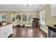 View of a brightly lit open concept kitchen area with access to a sunroom, and hardwood floors throughout at 219 1St St, Woodstock, GA 30188