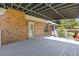Large covered deck features brick exterior and wood flooring, offering a comfortable outdoor space at 425 Houze Way, Roswell, GA 30076