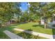 Serene backyard boasts a vast lawn, mature trees, and a charming outbuilding, perfect for relaxation at 425 Houze Way, Roswell, GA 30076