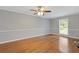 Bedroom with hardwood floors, neutral paint, a ceiling fan, and a window overlooking the yard at 425 Houze Way, Roswell, GA 30076