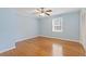 This bedroom has hardwood floors, light blue paint, a ceiling fan, and natural light from window at 425 Houze Way, Roswell, GA 30076