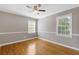 This bedroom has hardwood floors, neutral paint, a ceiling fan, and natural light from two windows at 425 Houze Way, Roswell, GA 30076